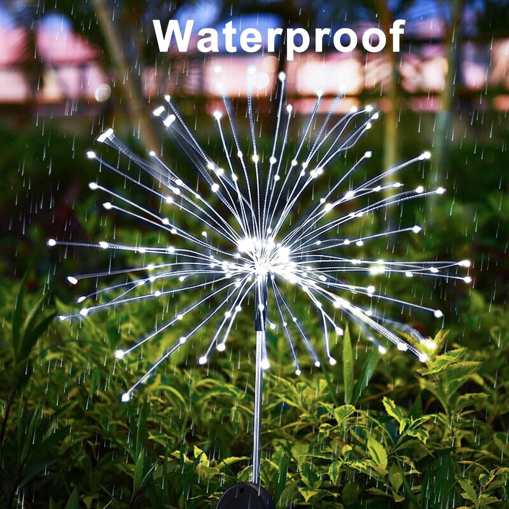 Solar firework stake light with cool-white LED spark burst glowing outdoors