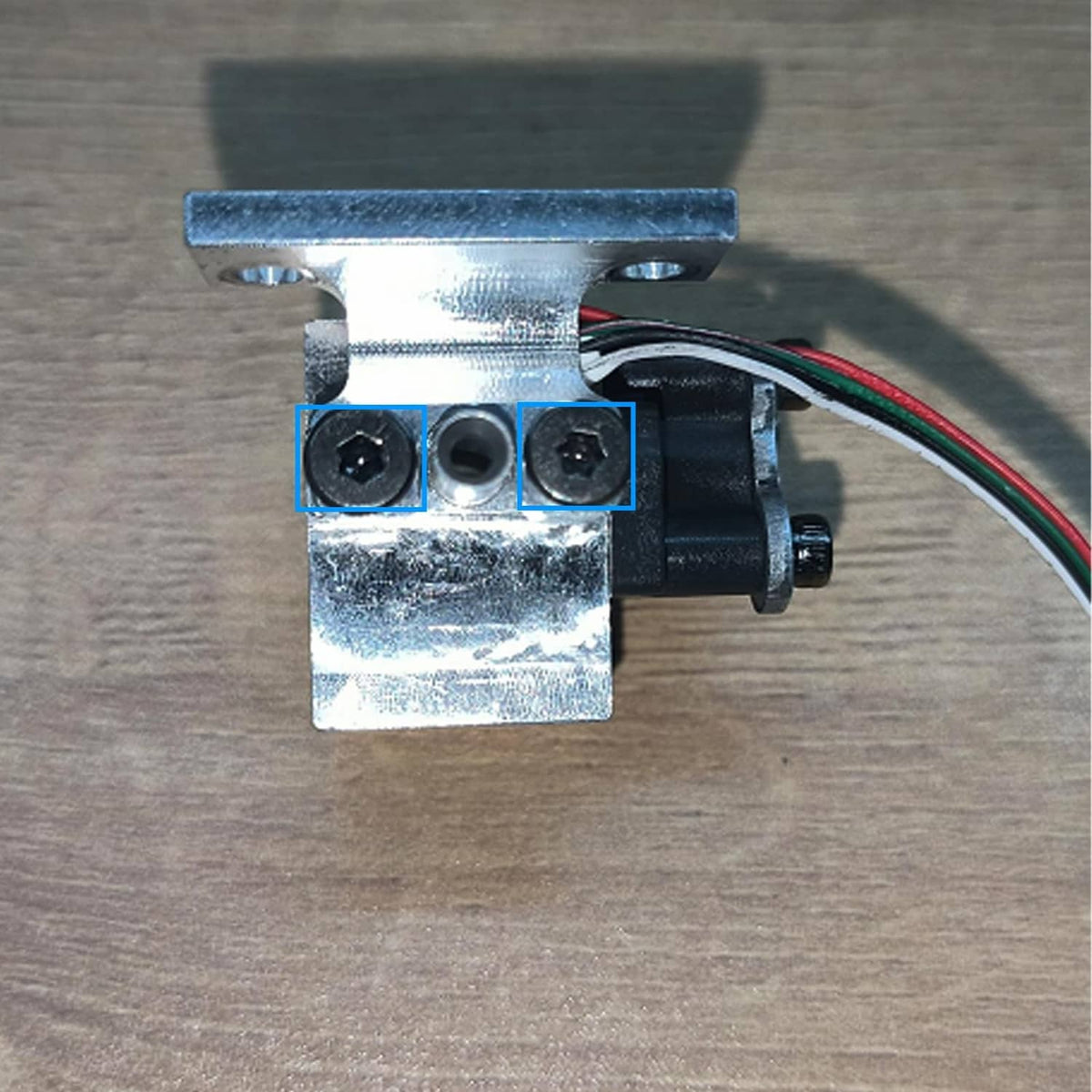 Metal strain gauge mounting bracket with screw holes and multicolor cable