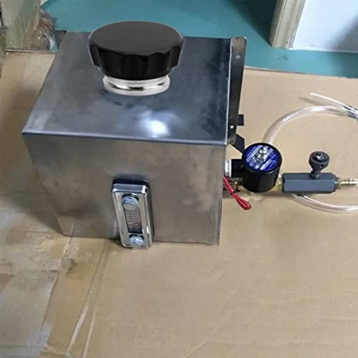 Black ridged filler neck cap mounted on a metal reservoir panel