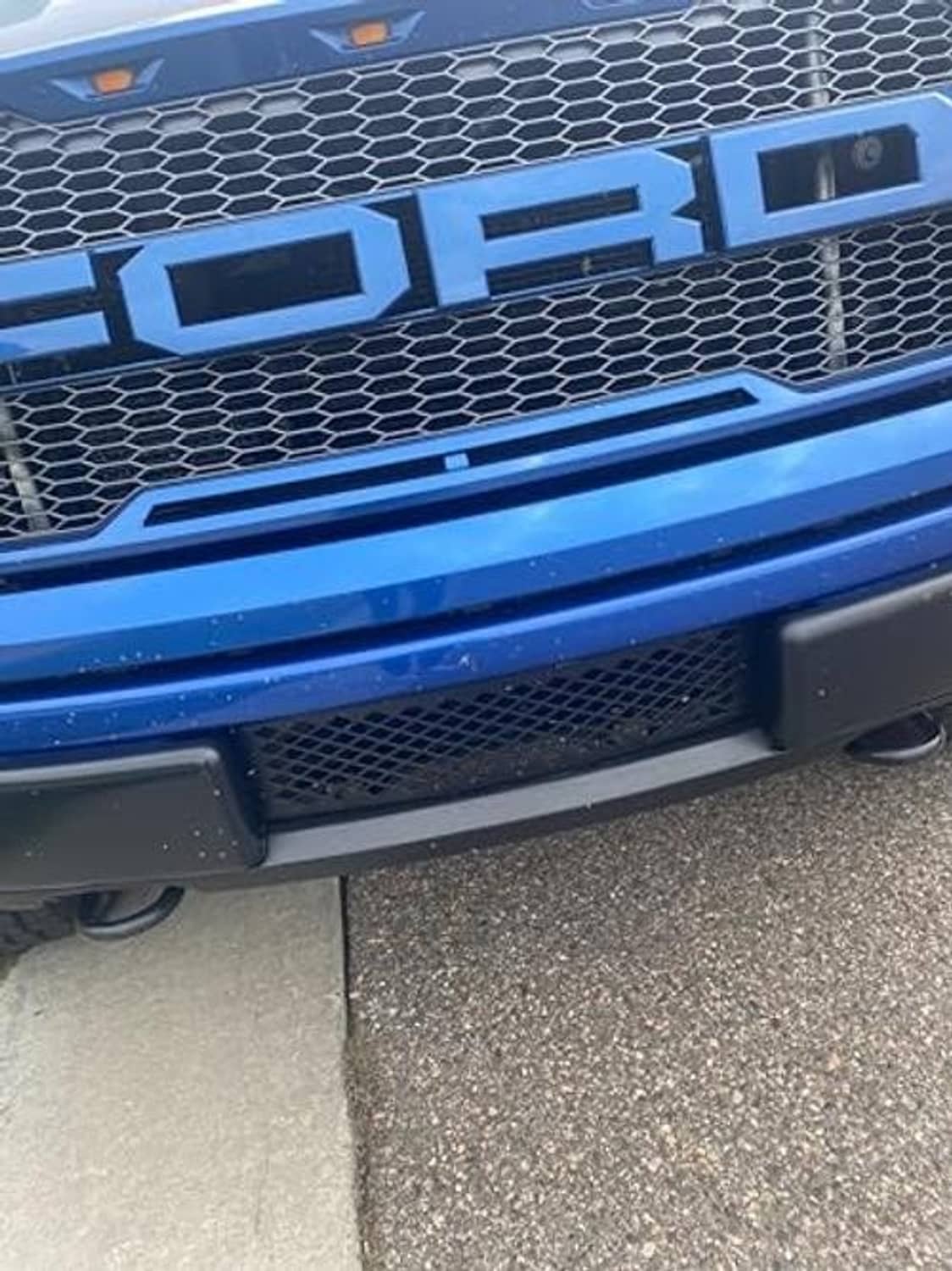 Installed black diamond-mesh bumper grille insert on front bumper opening