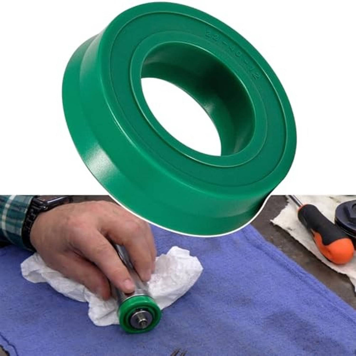 Hydraulic floor jack U-cup seal replacement being fitted, green seal held over bedding