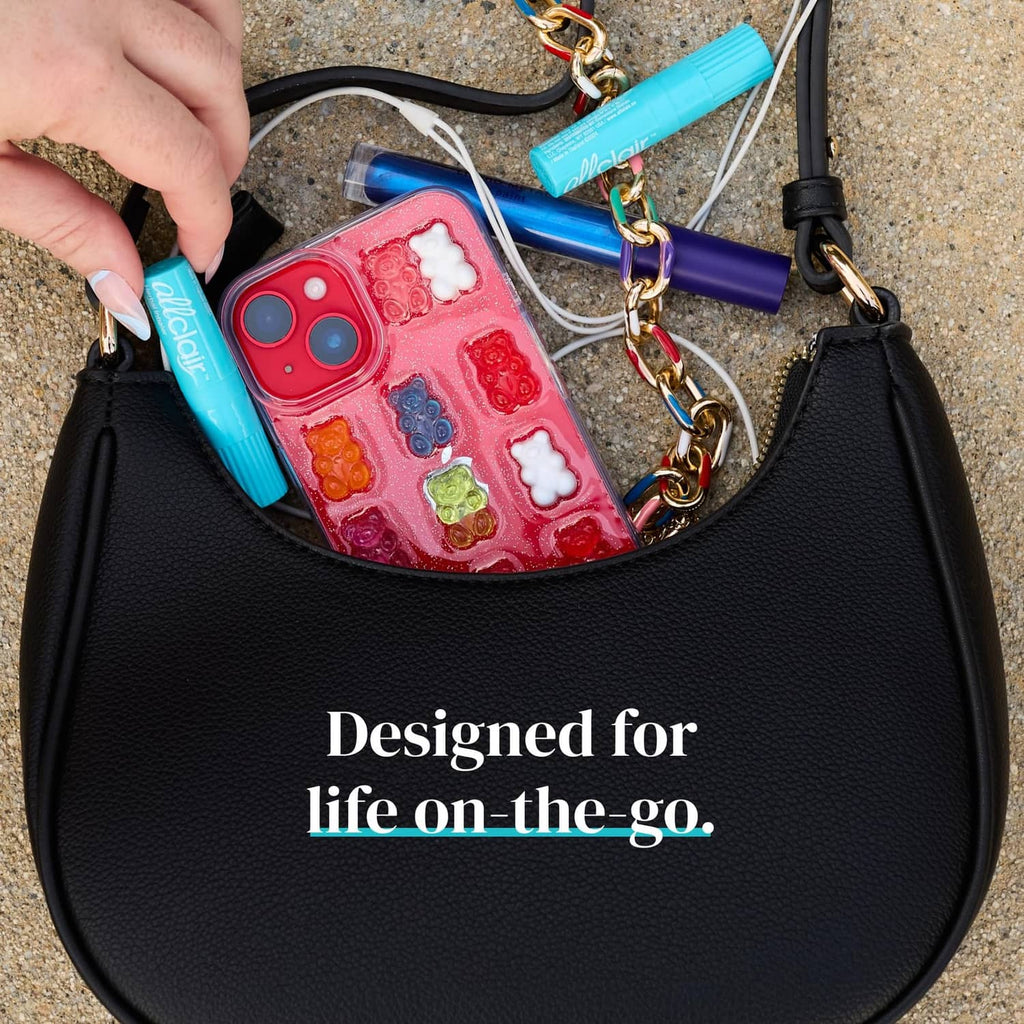 Turquoise herbal inhaler stick clipped in an open bag pocket near a phone case