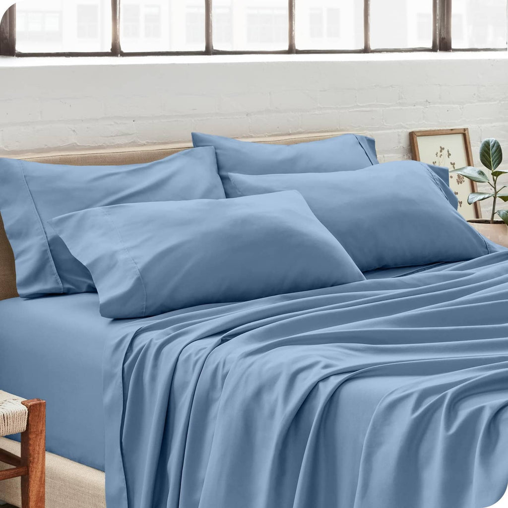 Light blue pillowcases on a made bed with coordinating bedding