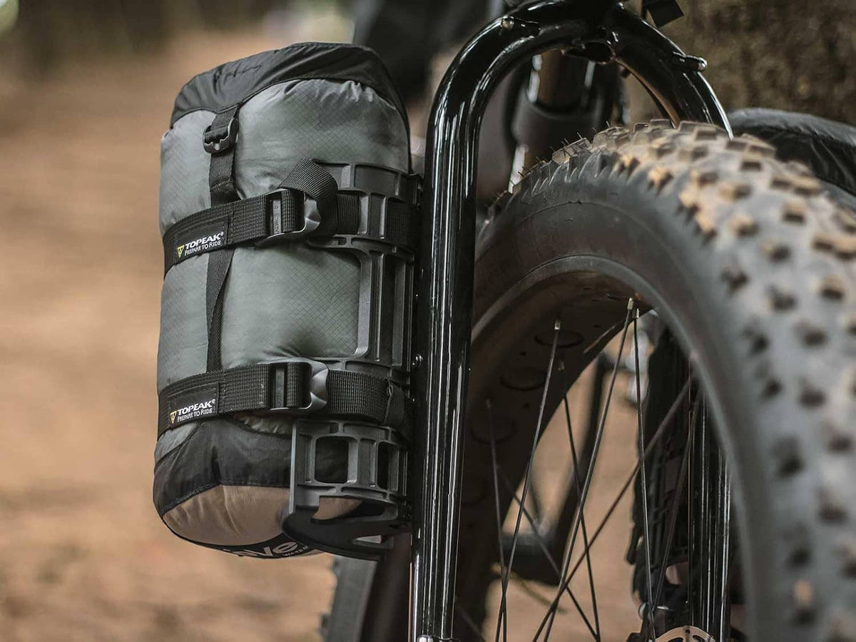 Black fork-mounted cargo bag with adjustable straps on wheel frame
