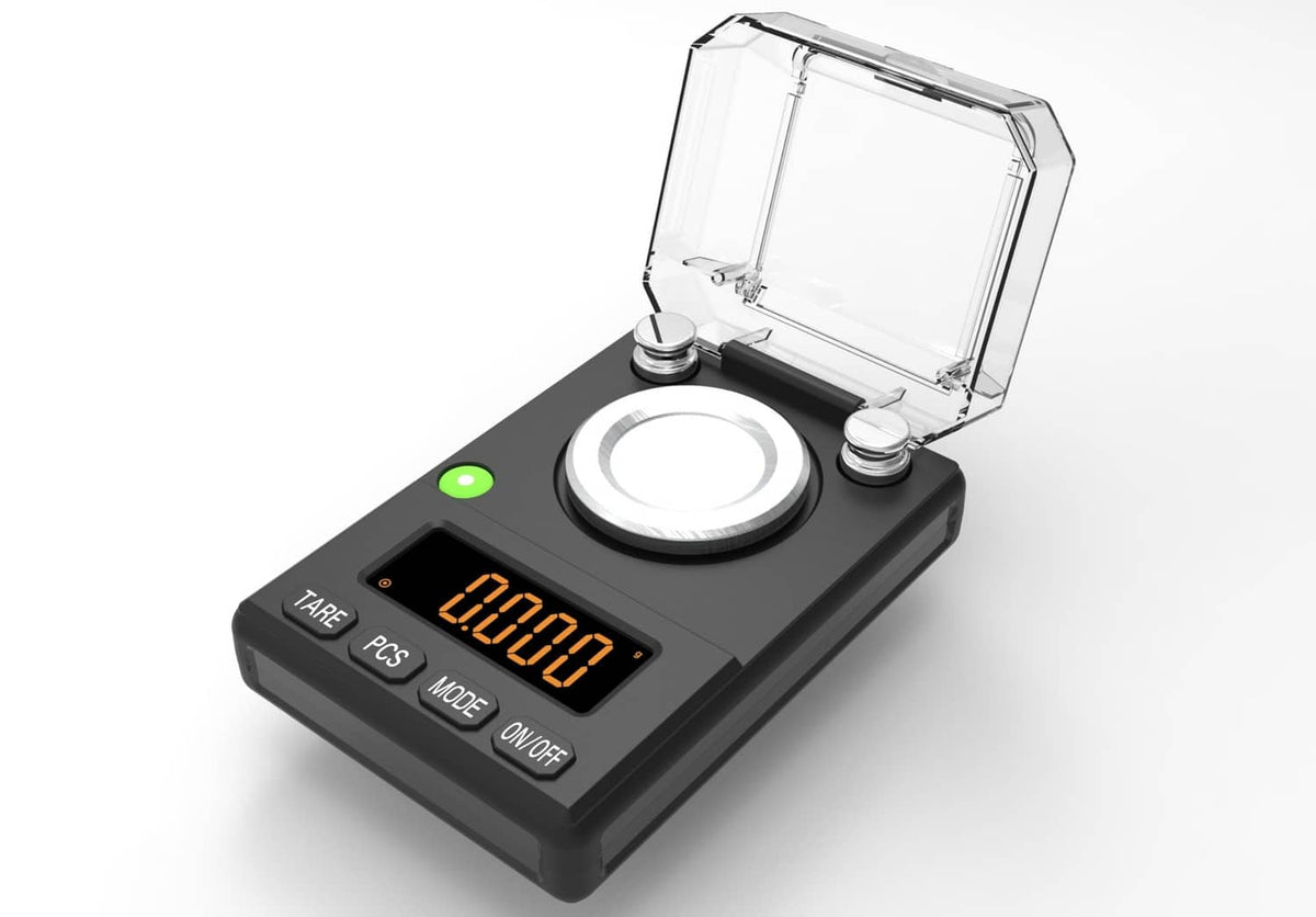 Black milligram scale with clear lid open and orange LED reading on front screen