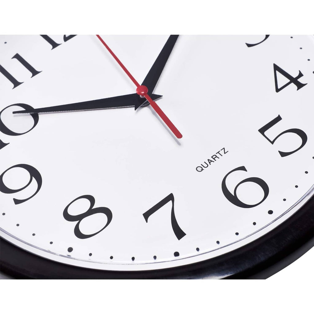Close-up of black wall clock hands with red second hand on white dial