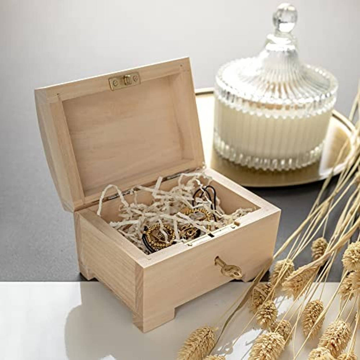 Open wooden jewelry box with compartment holding assorted jewelry pieces