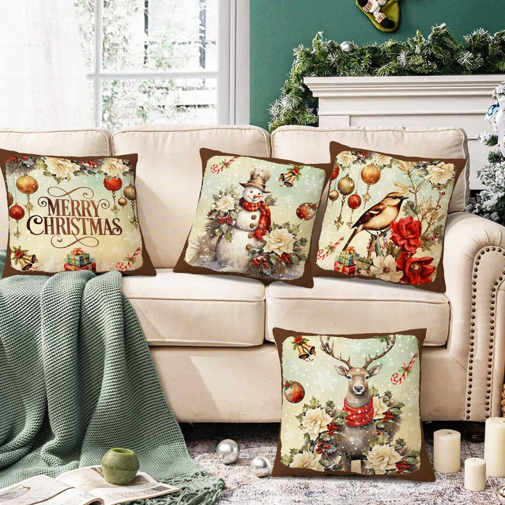 Set of 4 Christmas decorative throw pillows on sofa: Merry Christmas, snowman, bird, deer