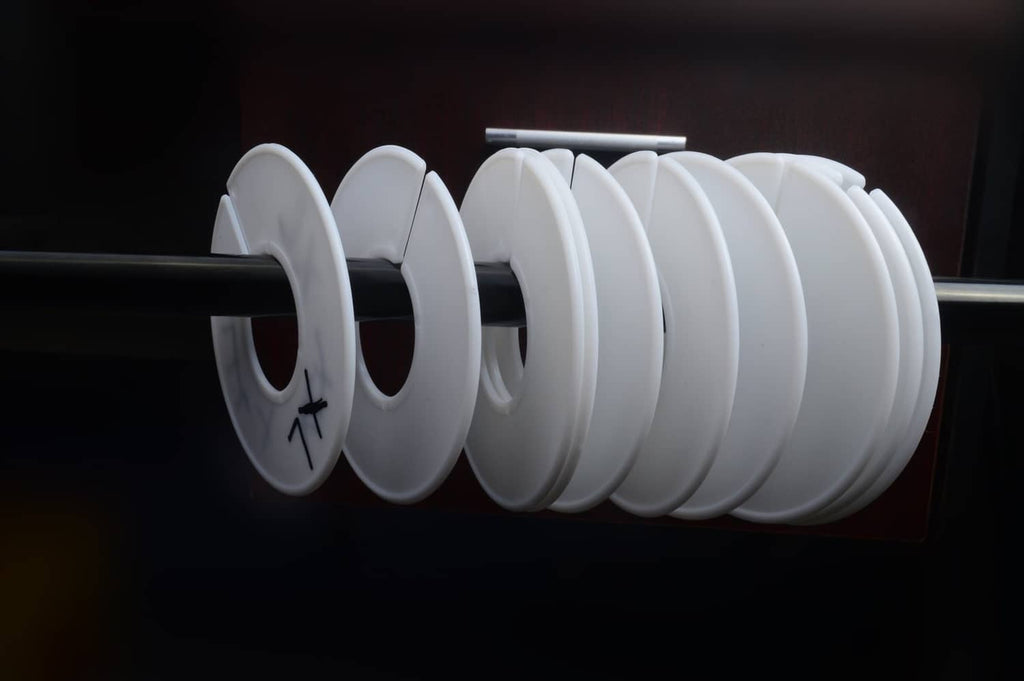 White round clothing rack dividers spaced along a horizontal rod