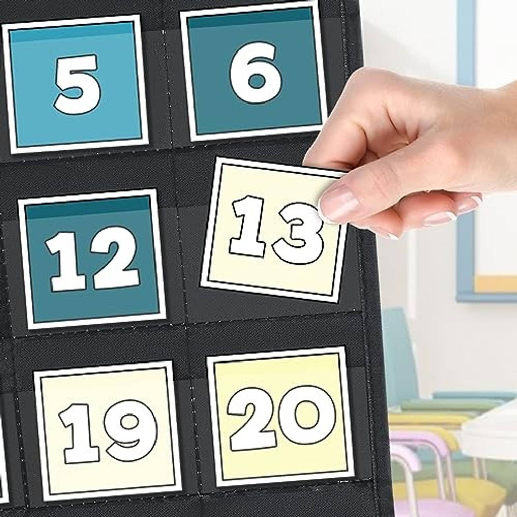 Hand placing numbered date cards into black pocket calendar chart
