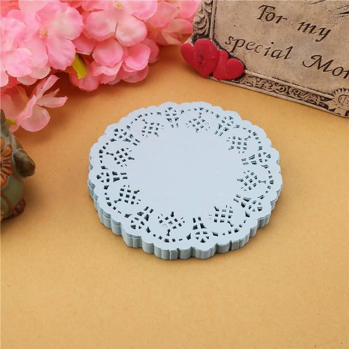 Round light blue paper lace doily with scalloped rim and openwork lattice design