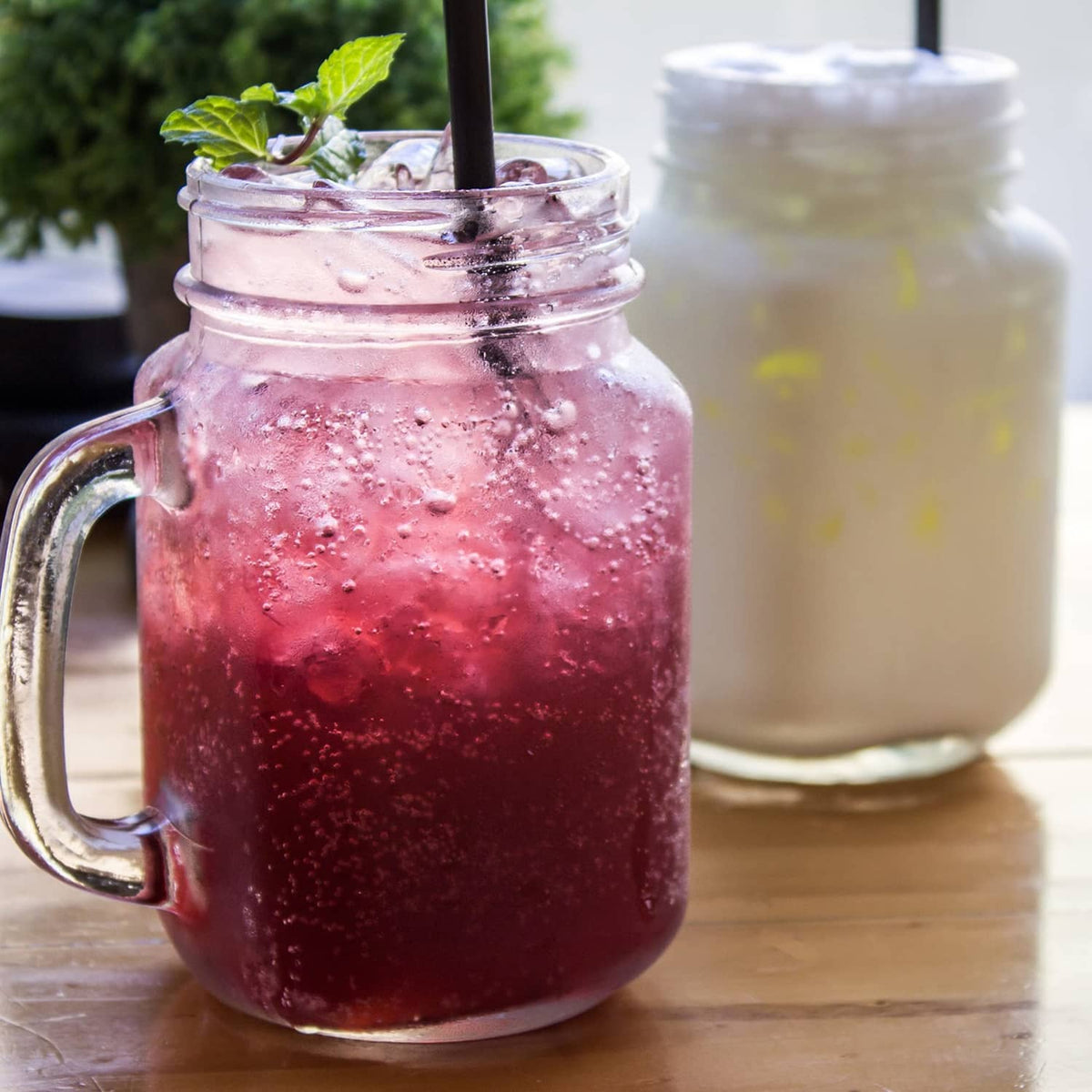 Jar of purple kefir with bubbles and a second jar in background