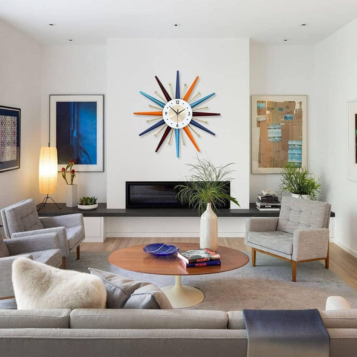 Starburst wall clock with multicolor rays and white dial mounted on the wall.
