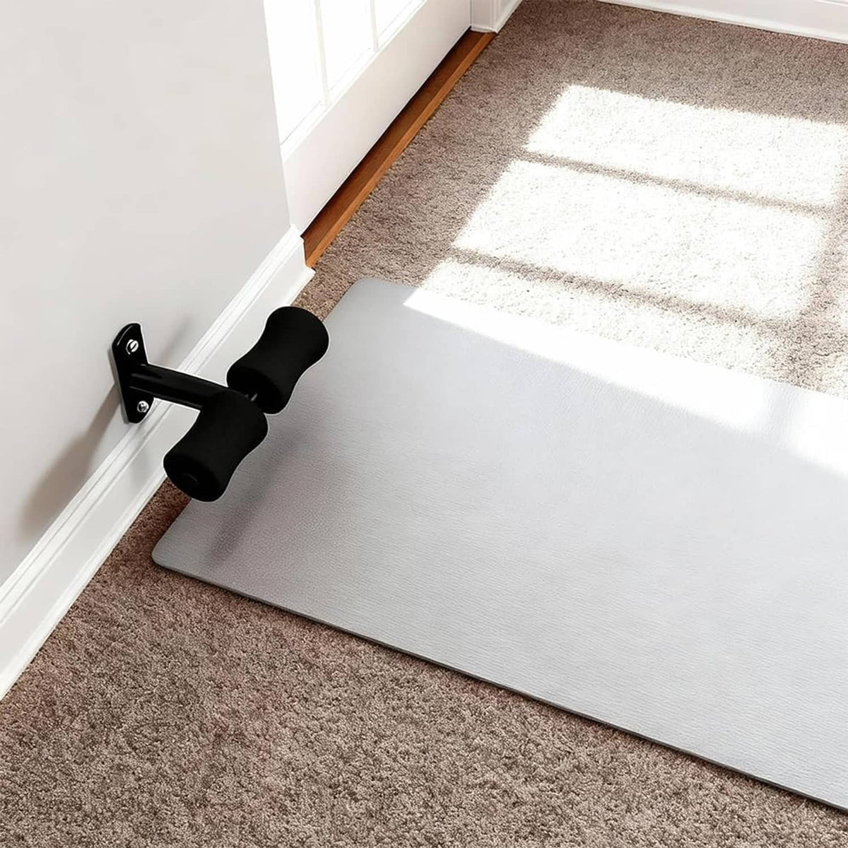 Wall-mounted sit-up foot holder installed on a wall with black foam rollers.