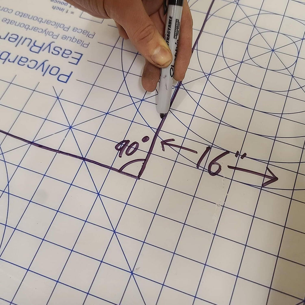 Clear polycarbonate sheet being cut or scored with a marker on a grid surface