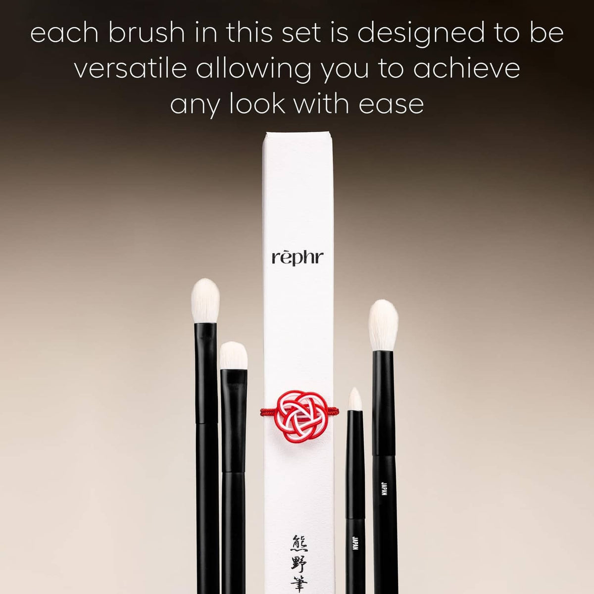 Four eye makeup brushes with cream bristles beside white sleeve