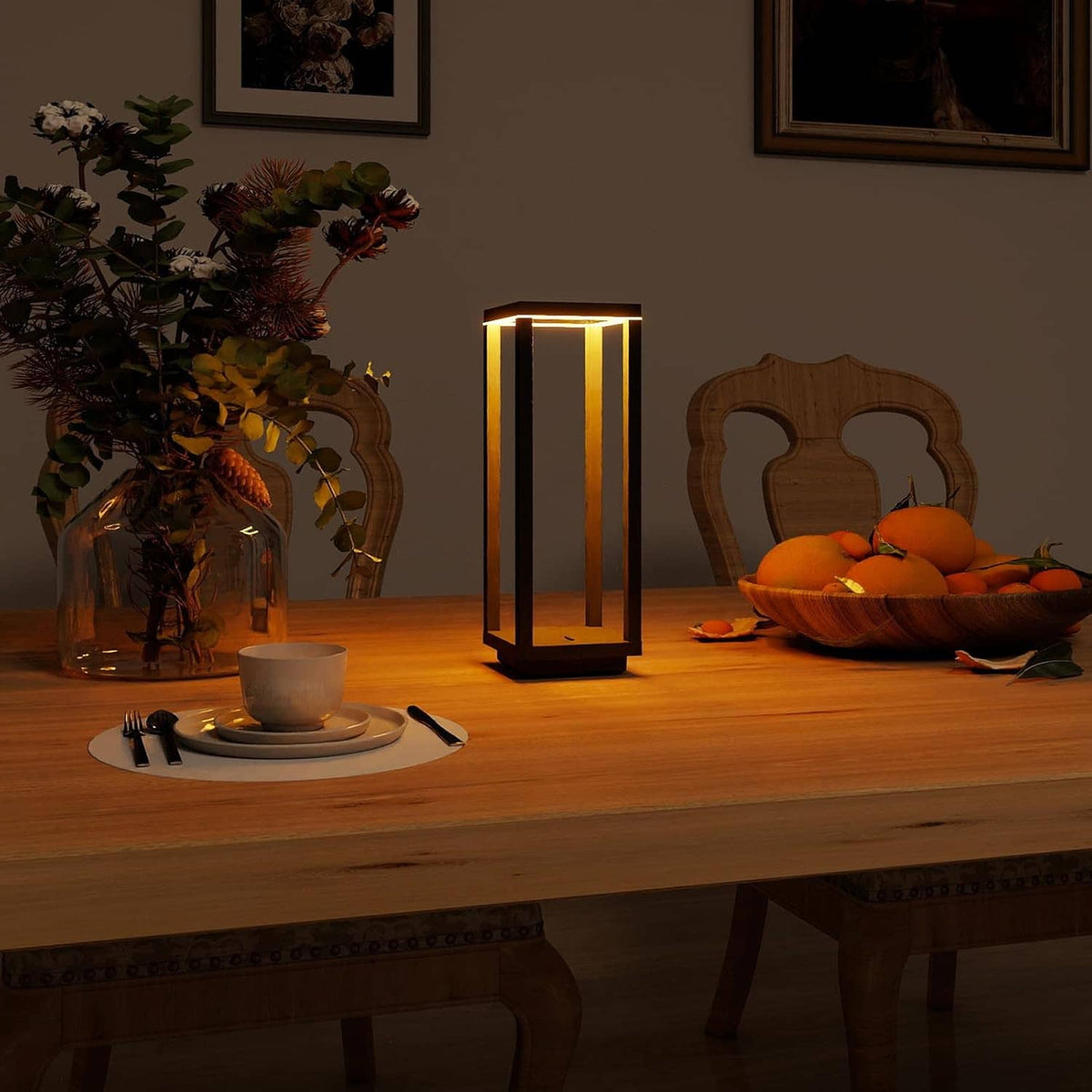 Black lantern table lamp with warm glow on dining table, cordless lantern shape
