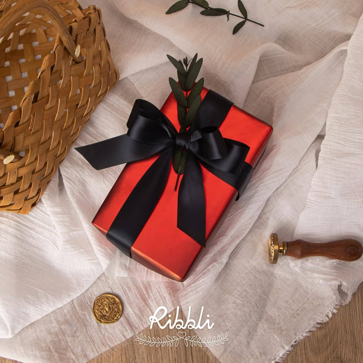 Black satin ribbon bow on a wrapped gift, with ribbon tails