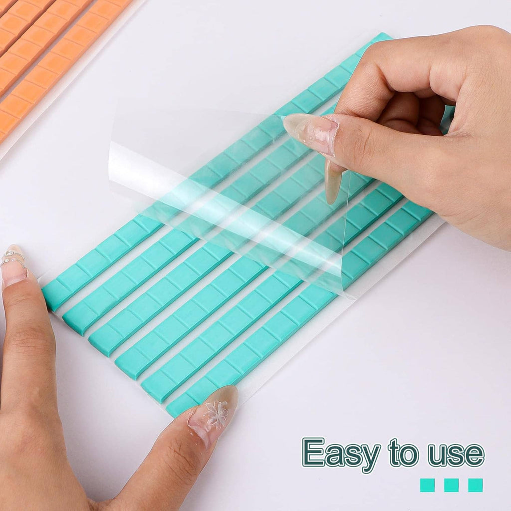 Teal adhesive putty strip pressed onto paper by hands, removable and reusable