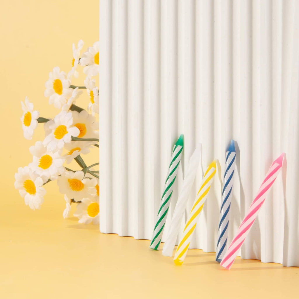 Set of multicolored striped birthday candles standing in a row