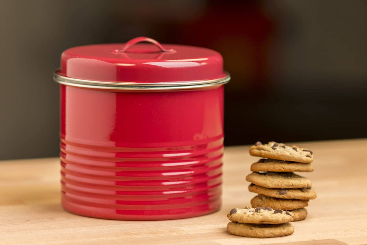 Red lidded ceramic container with stacked cookies on a wooden table