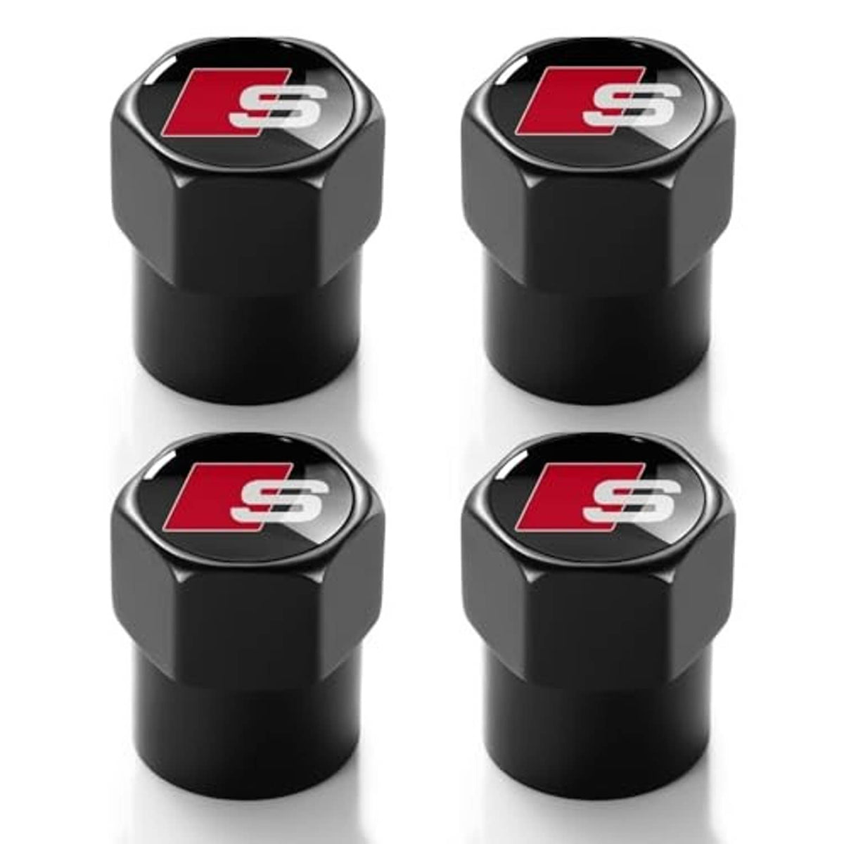 Four black tire valve stem caps with red S emblem on rounded metal-look tops