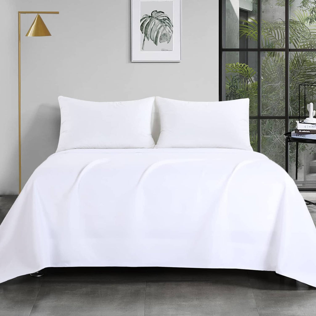 White flat sheet on a king bed with two pillows, smooth drape