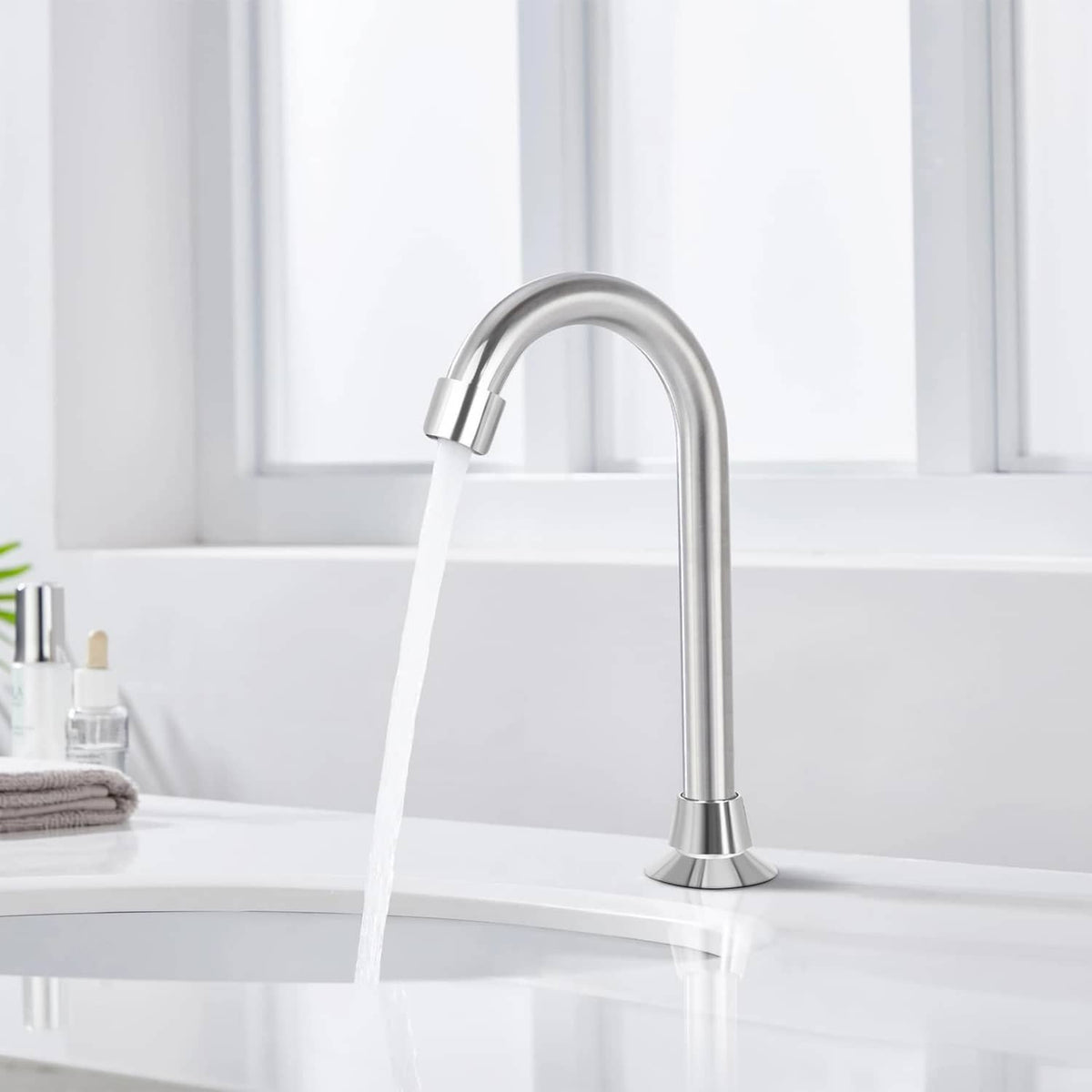 Chrome floor-mount sink faucet with curved spout and running water stream