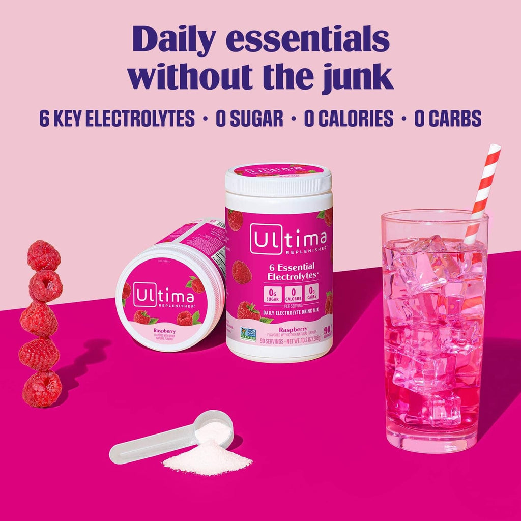 Raspberry electrolyte drink mix tubs with scoop and glass of pink drink.