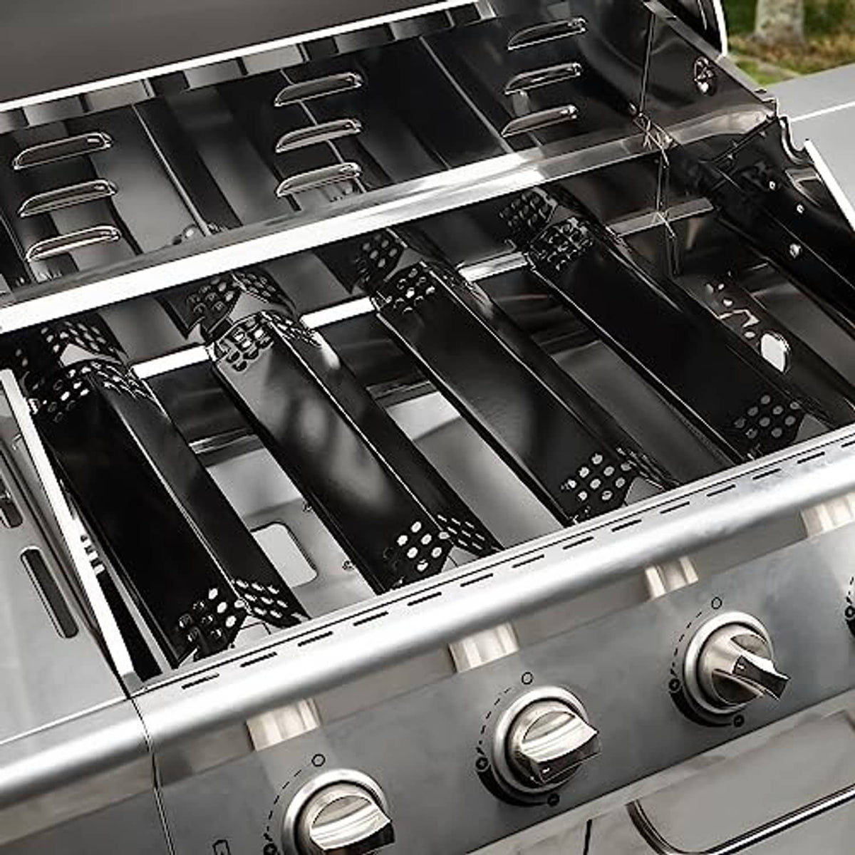 Stainless grill with black perforated burner covers and drip shield panels
