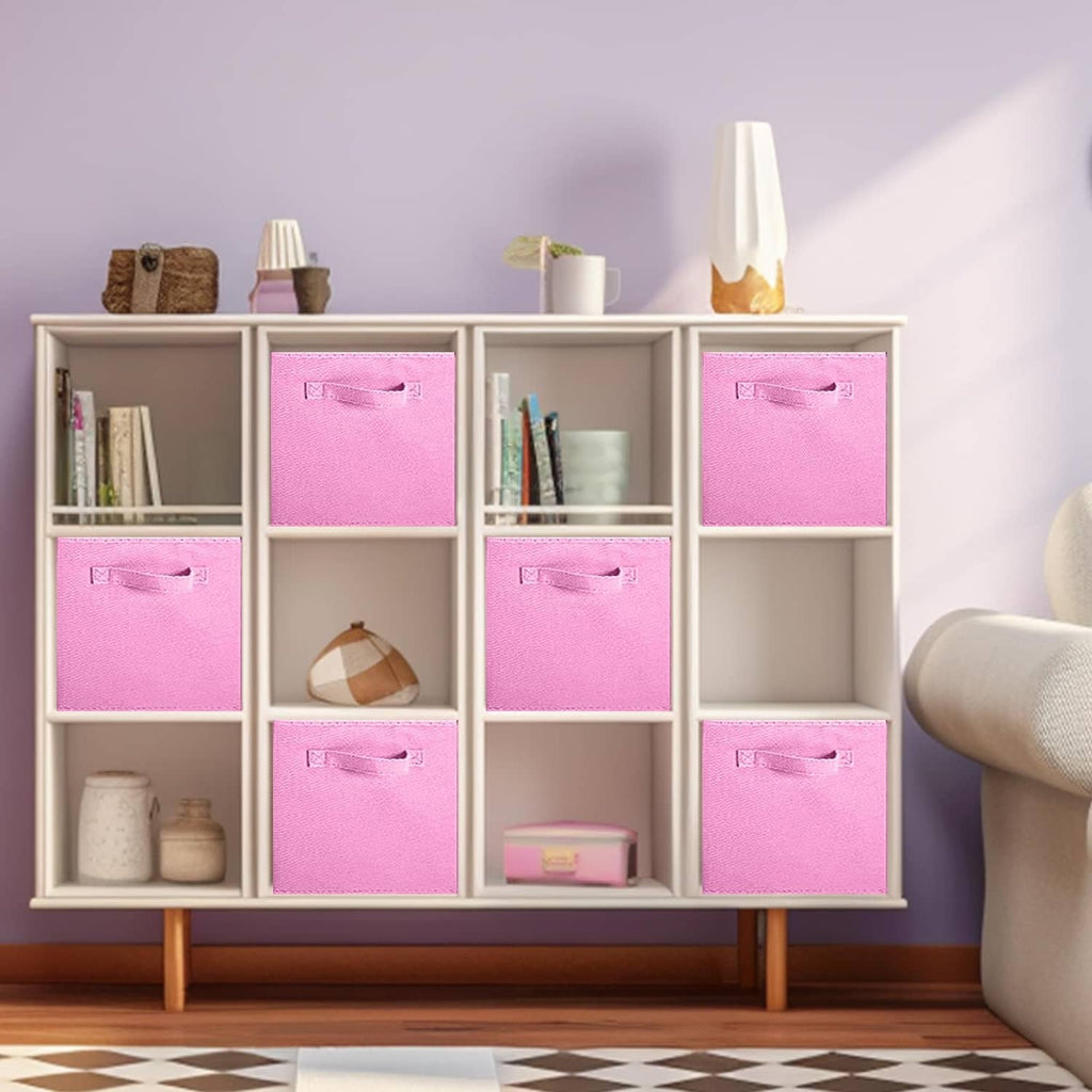 Pink fabric storage cube bins with stitched front handles in a shelf unit