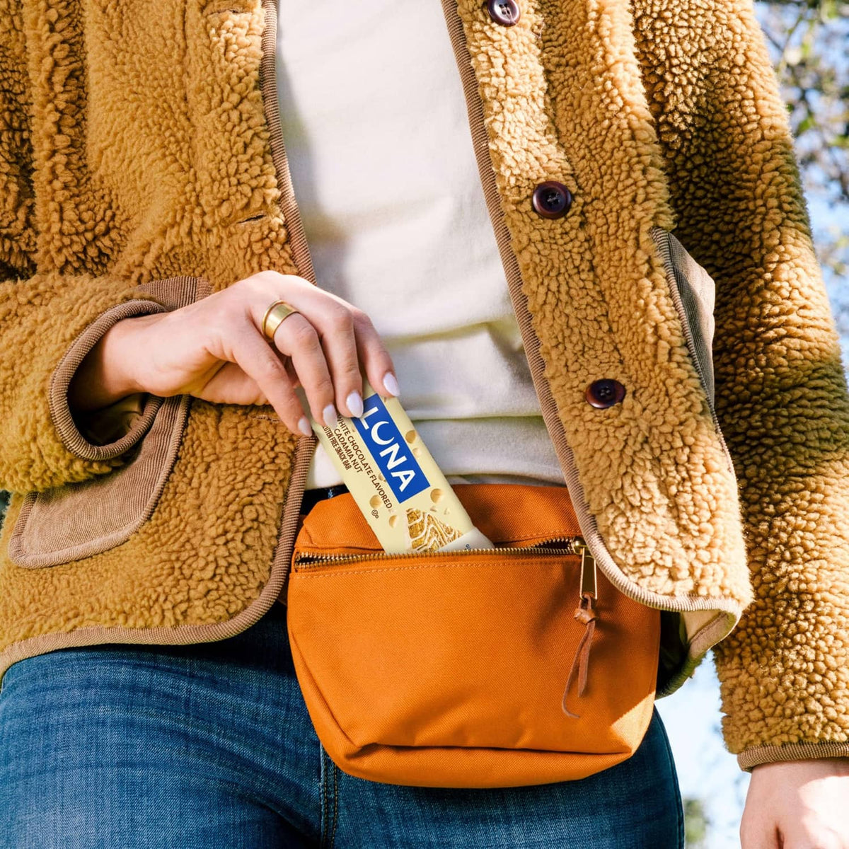 Hand holding a LUNA white chocolate macadamia nut snack bar