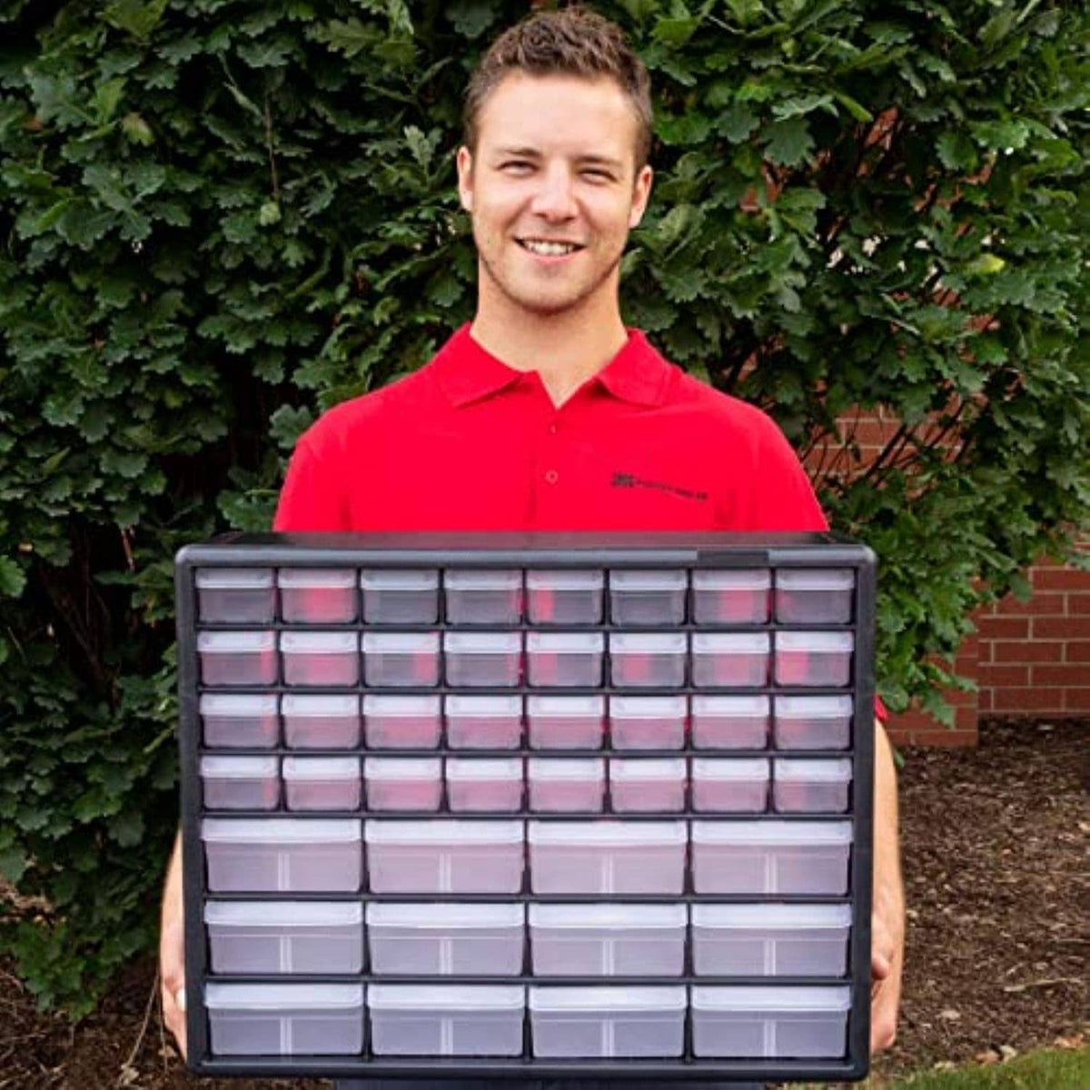 Black plastic storage cabinet with clear drawers, held up by a person
