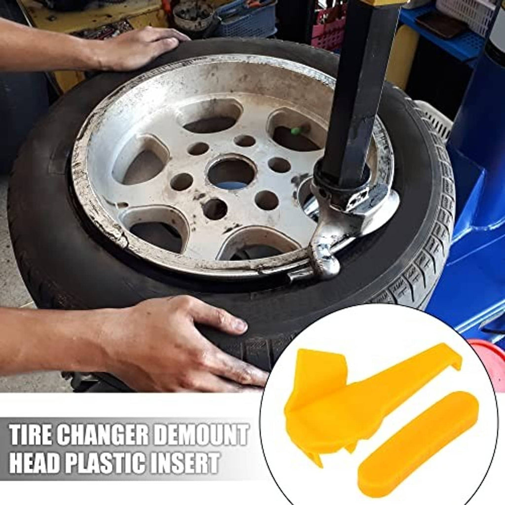 Yellow plastic tire changer demount head insert set shown near a wheel