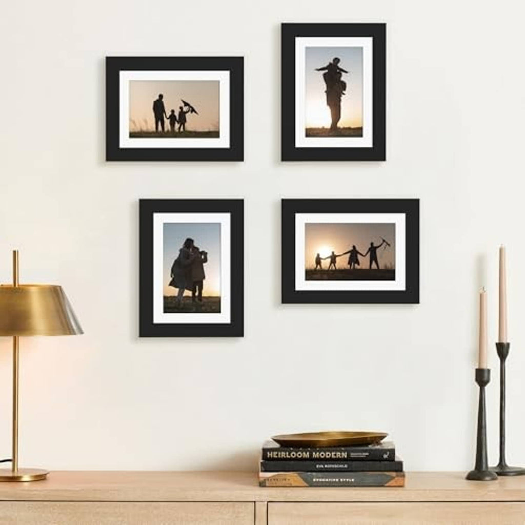 Four black wood picture frames arranged on wall with portrait and landscape photos