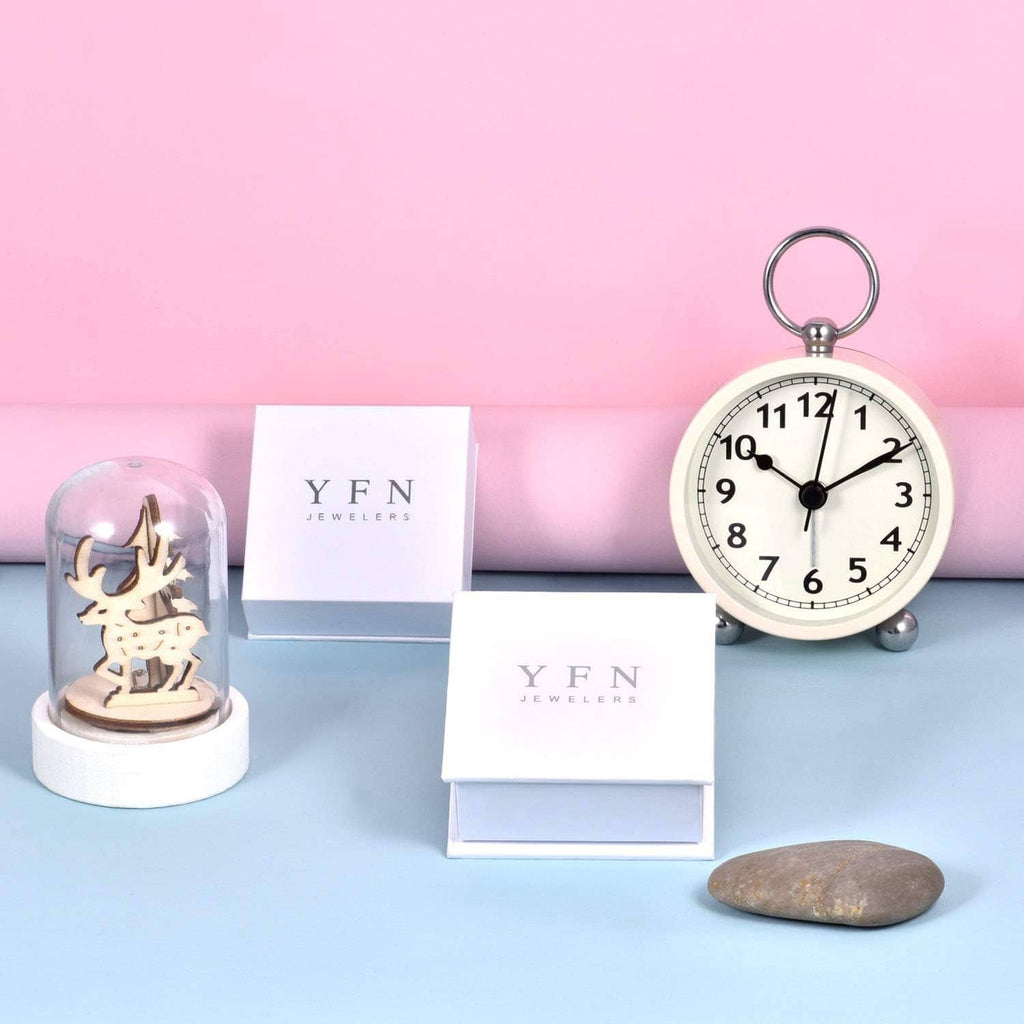 Jewelry display with branded boxes and alarm clock; necklace not visible