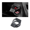 Carbon fiber engine start/stop button cover with textured black weave, installed on car