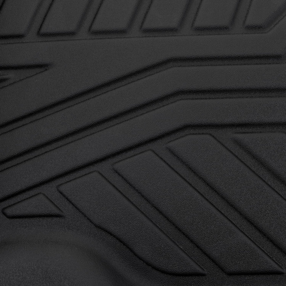 Black TPE floor mat close-up with raised non-slip ridges and channel lines