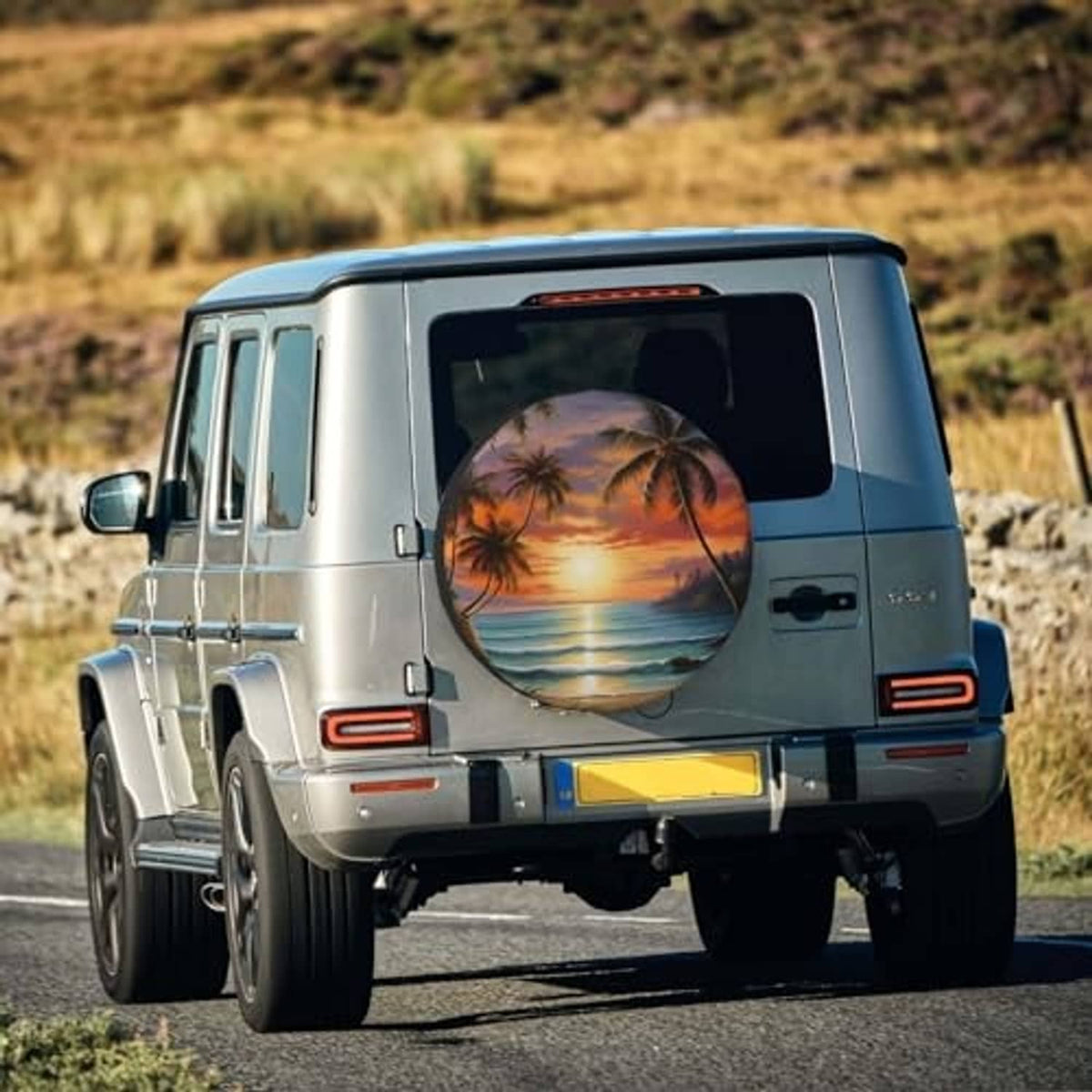 Spare tire cover on rear of SUV, tropical ocean sunset artwork with palm trees