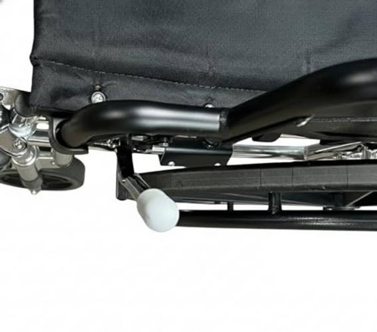Wheelchair brake handle extension near wheel, white grip end and metal bar
