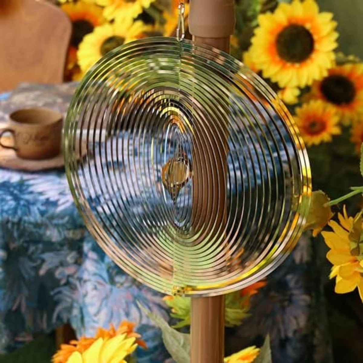Silver round wind spinner on a post with concentric metal rings and hanging hook