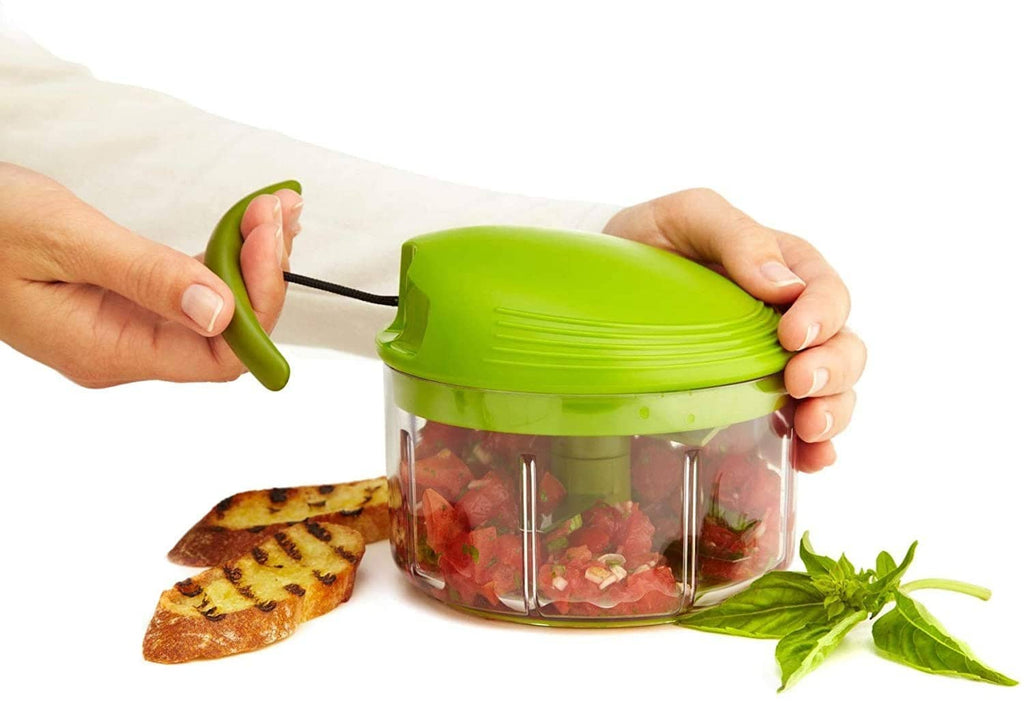 Hands using a pull-cord green food chopper to chop ingredients in the clear bowl