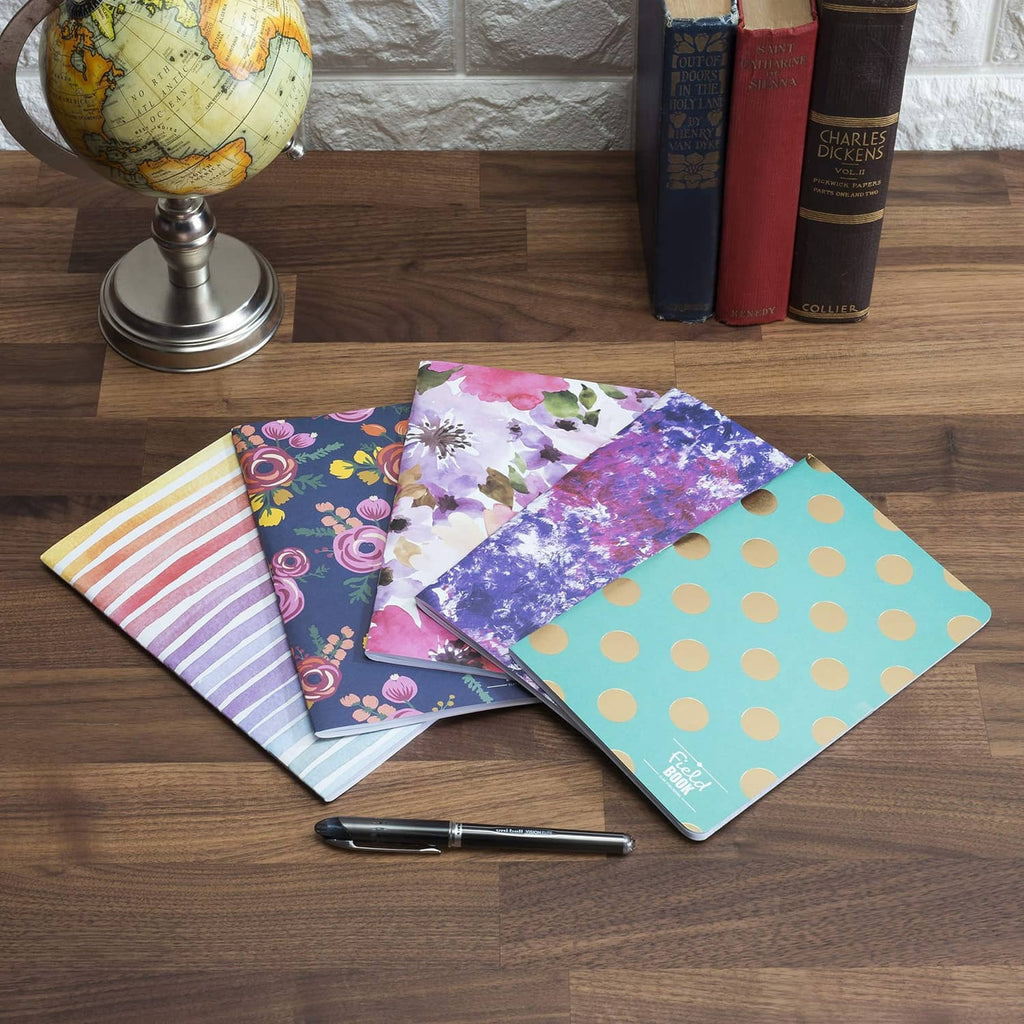 Set of five patterned 5x8 notebooks on tabletop, assorted cover designs