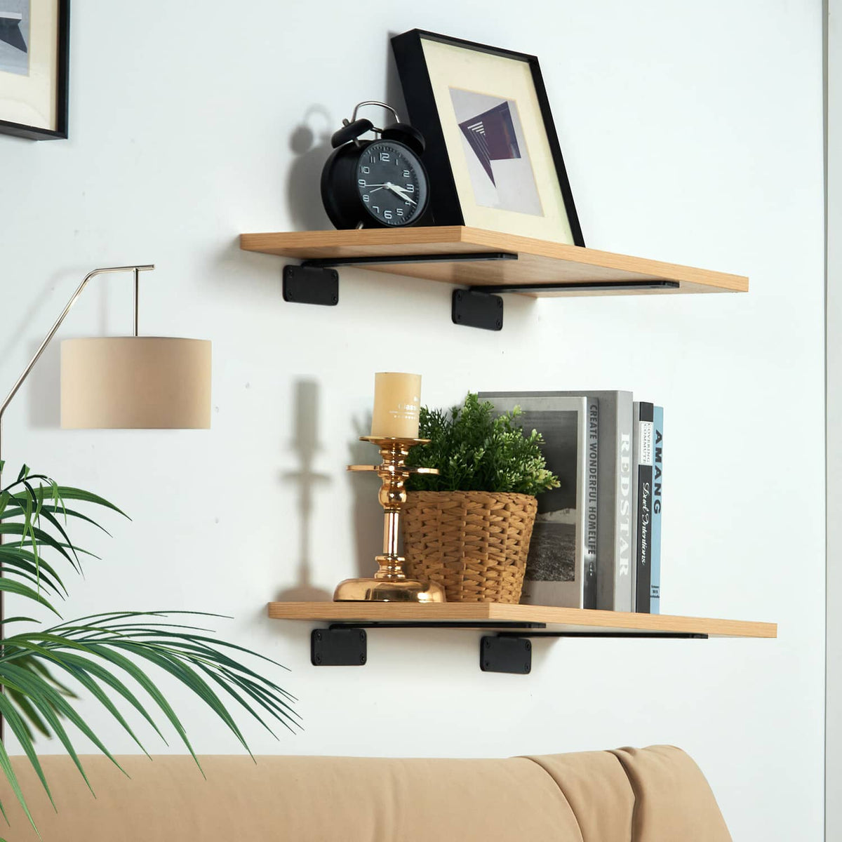Black floating shelf brackets holding two light wood shelves on wall mounts