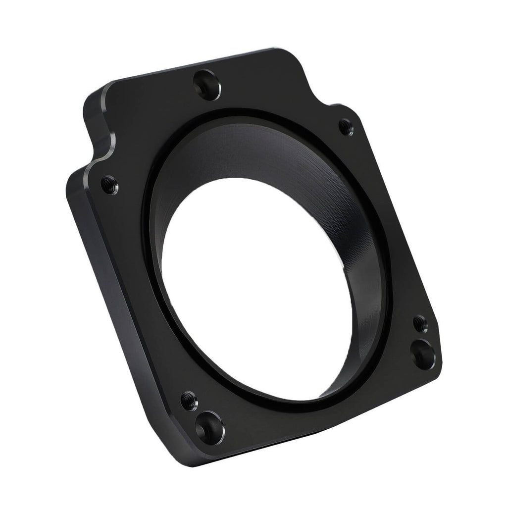 Black intake manifold spacer adapter plate with round bore and four bolt holes