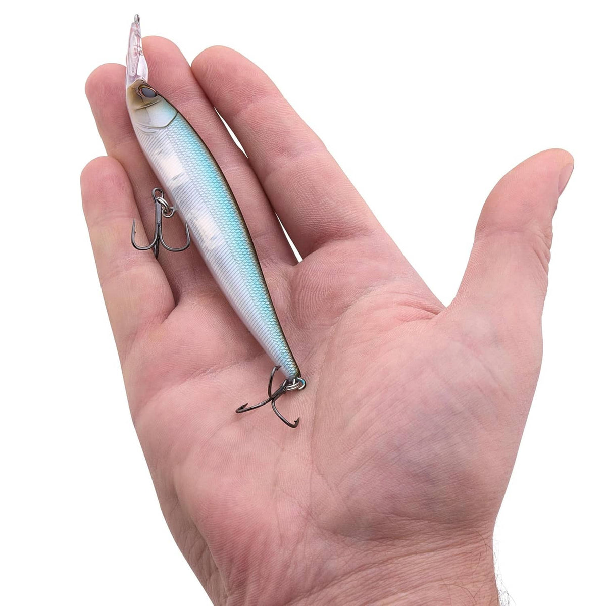 Blue-silver minnow fishing lure in open hand, treble hooks visible