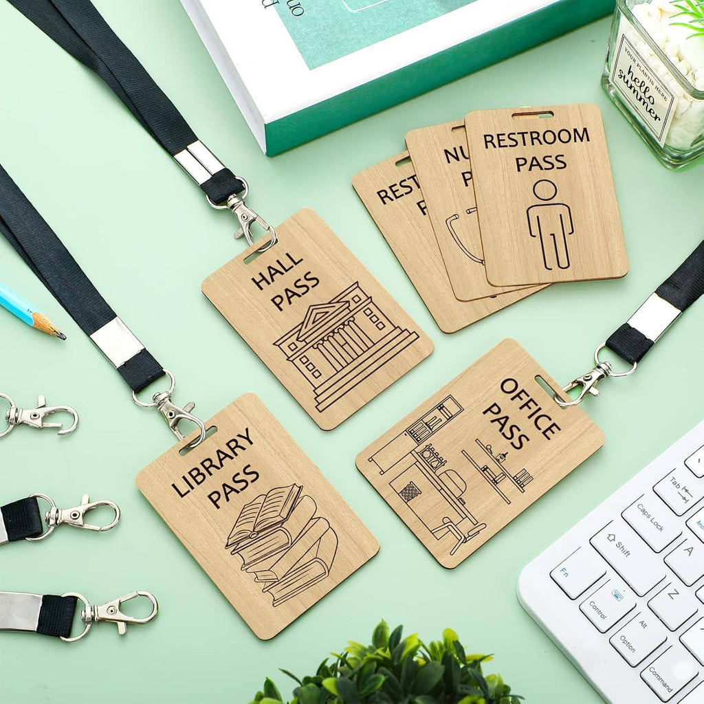 Wooden pass cards and black lanyards laid out on a desk surface with clips