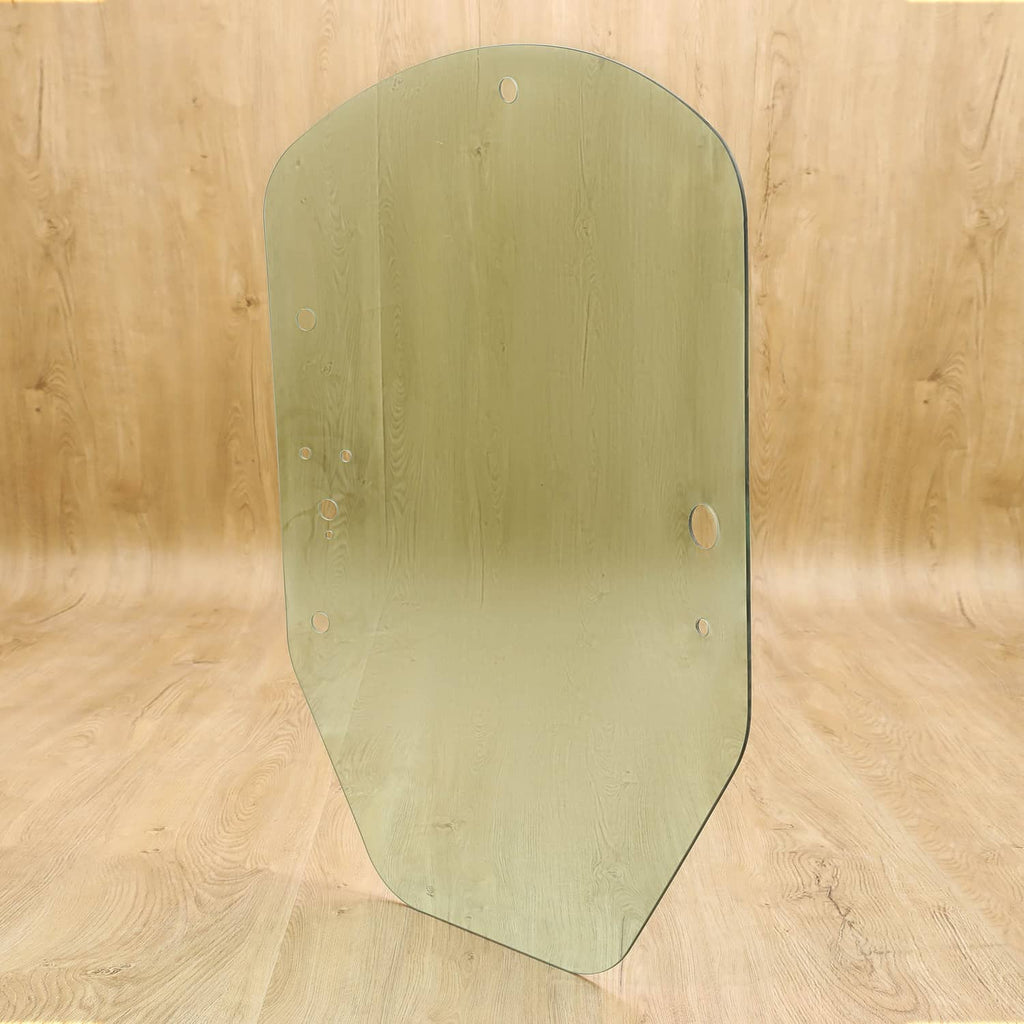 Skid steer cab door glass panel, green tinted, rounded arch shape with mounting holes