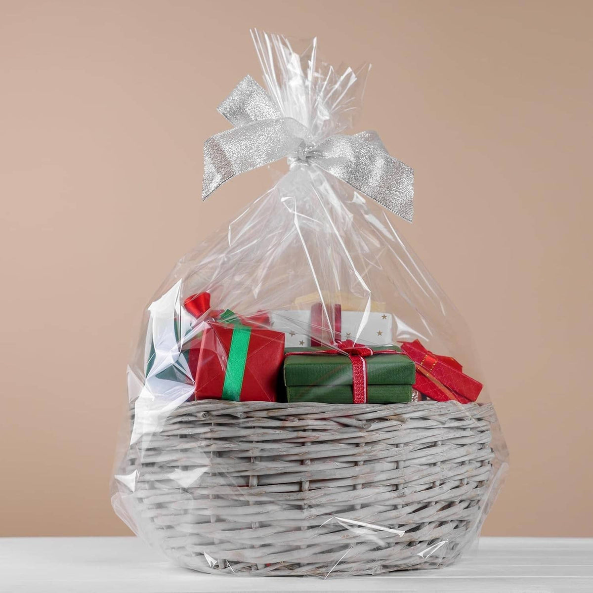 Clear PVC shrink wrap bag over a gift basket with a silver bow tie