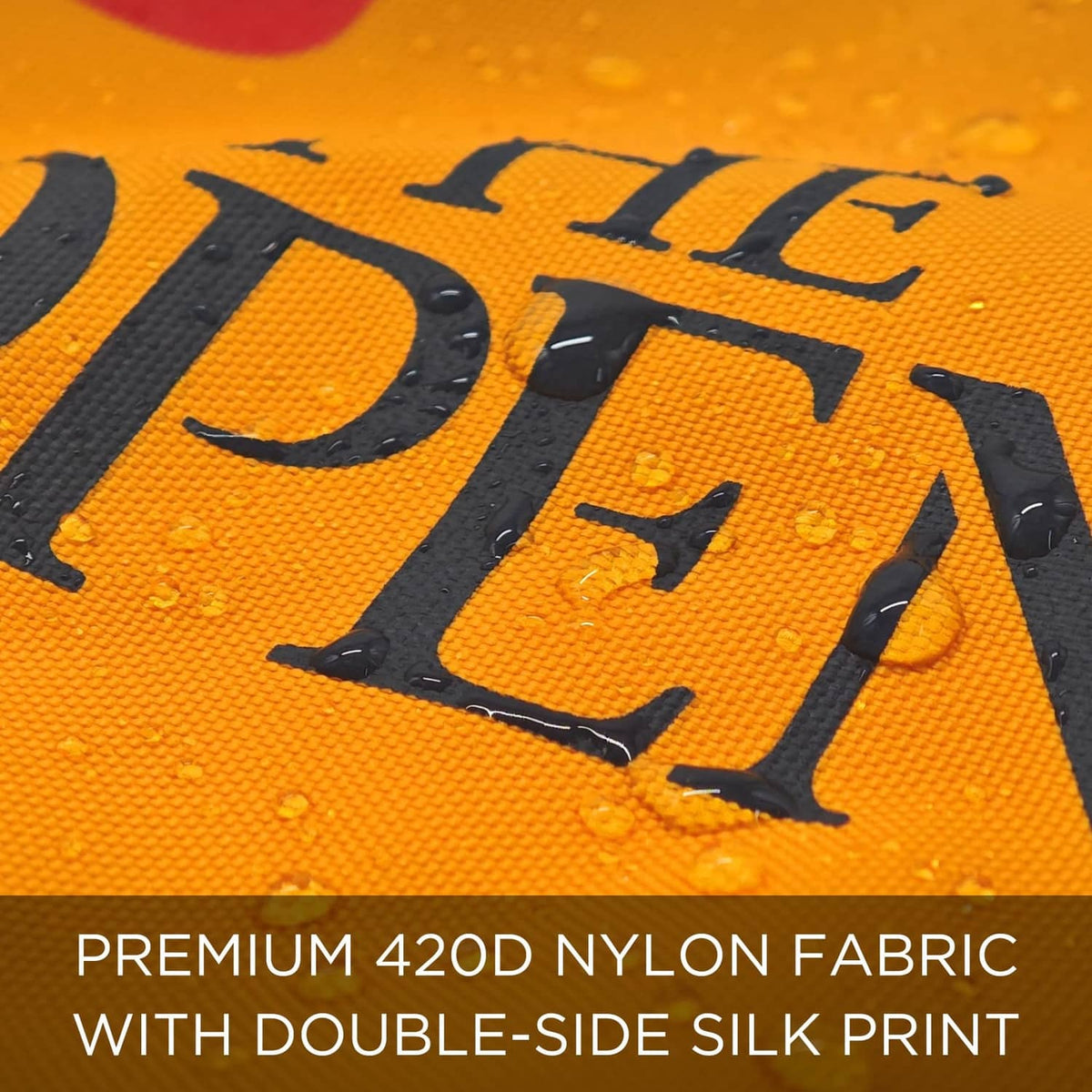 Close-up of orange-yellow fabric with bold black 'The Open' 18 print